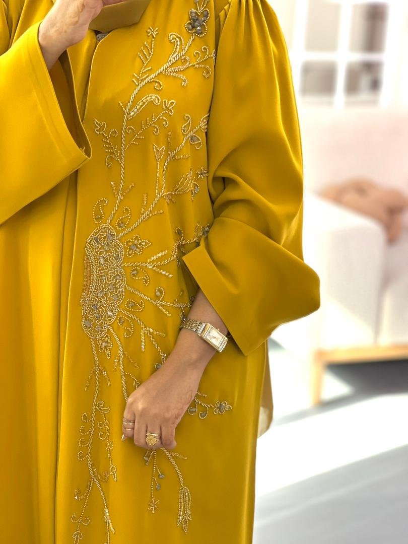 Golden yellow abaya made from high premium Barbie fabric with elegant hand-beaded floral embroidery, perfect for Eid and special occasions.