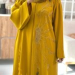 Golden yellow abaya made from high premium Barbie fabric with elegant hand-beaded floral embroidery, perfect for Eid and special occasions.